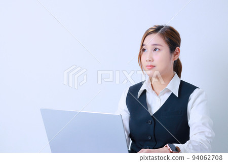 Young woman who cares about time during desk work Young woman who cares about time during desk work 94062708