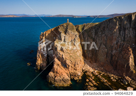 Two sea stacks in the sea. Abandoned lighthouse on top of a rocky island Two sea stacks in the sea. Abandoned lighthouse on top of a rocky island 94064829