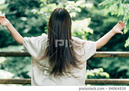 A woman with beautiful hair in the forest (black hair) A woman with beautiful hair in the forest (black hair) 94064830