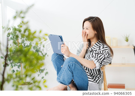 A woman watching a tablet terminal 94066305