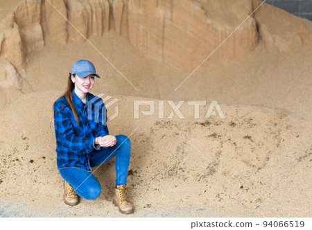 Woman farmer checking quality of soybean husk Woman farmer checking quality of soybean husk 94066519