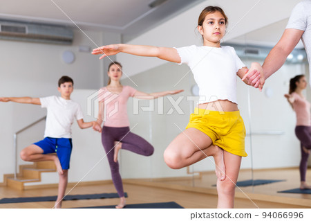 Girl practicing yoga at studio with family 94066996