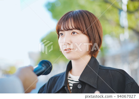 A woman undergoing a street interview A woman undergoing a street interview 94067027