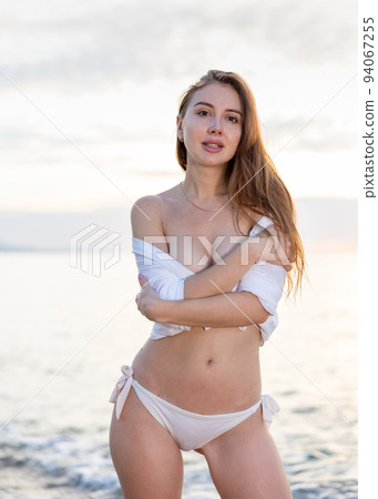 Woman with athletic body on a tropical beach wearing white bikini Woman with athletic body on a tropical beach wearing white bikini 94067255