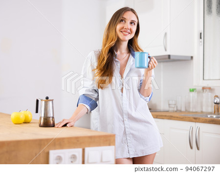 Woman drinking coffee at kitchen in morning 94067297