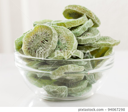 Dried tropic fruit kiwi in glass bowl on white surface 94067298
