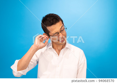 A man who is worried about the inside of his ear and is sticking his finger in A man who is worried about the inside of his ear and is sticking his finger in 94068570