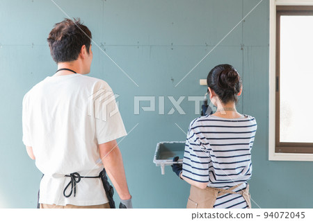 Back view of Japanese men and women painting walls (DIY, renovation, renovation) 94072045