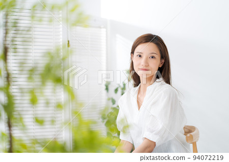 Portrait of a woman in her twenties sitting on a chair 94072219