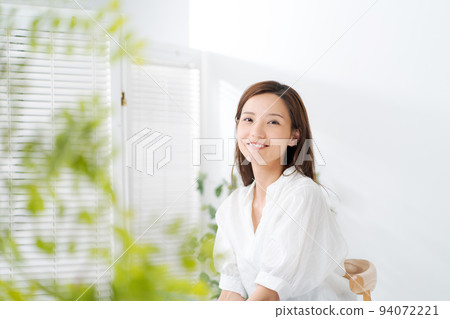 Portrait of a woman in her twenties sitting on a chair 94072221