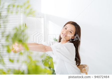 Portrait of a woman in her twenties sitting on a chair 94072464