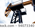 Modern oil rocking chair in a field of green grass. The concept of the cost of a barrel of oil, oil 94073340