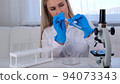 professional scientist takes a sample for a medical experiment. A research chemist works in a 94073343