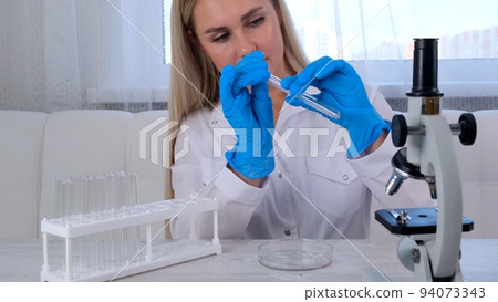 professional scientist takes a sample for a medical experiment. A research chemist works in a professional scientist takes a sample for a medical experiment. A research chemist works in a 94073343