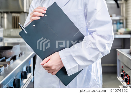 Image cut of a woman wearing a white coat in a restaurant kitchen 94074562