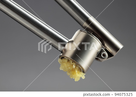 Squeeze the garlic with a garlic press. 94075325