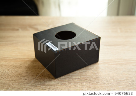 Closed rectangular cardboard box with corrugated cardboard lid, on oak wooden table Closed rectangular cardboard box with corrugated cardboard lid, on oak wooden table 94076658