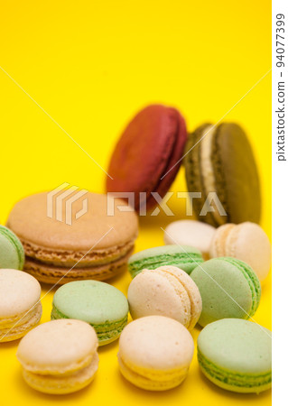 Tasty different macaroons flavour on yellow background. Sweet dessert Tasty different macaroons flavour on yellow background. Sweet dessert 94077399
