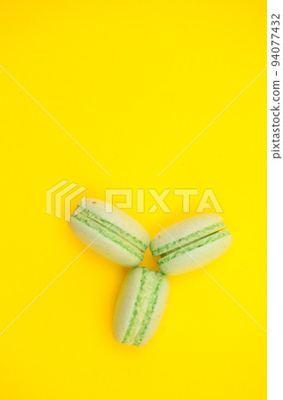 Top view of three sweet macaroons over yellow background. Luxury dessert Top view of three sweet macaroons over yellow background. Luxury dessert 94077432