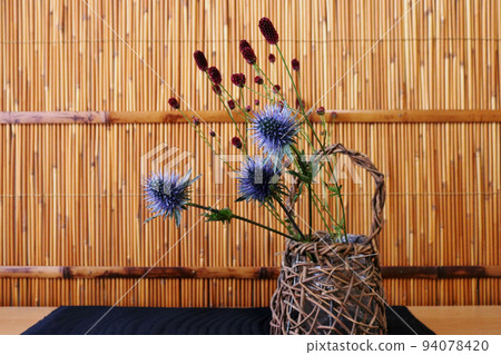 百葉窗前的插花 刺藤和地榆放在藤蔓編織的花瓶中 94078420