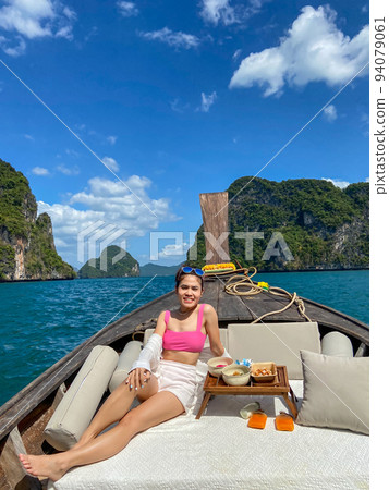 Woman tourist in private longtail boat trip to island with exotic food picnic, Krabi, Thailand. landmark, destination, Asia Travel, vacation, wanderlust and holiday concept 94079061
