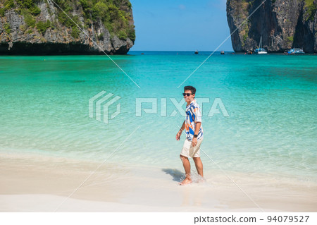 happy tourist man at Maya Bay beach on Phi Phi island, Krabi, Thailand. landmark, destination Southeast Asia Travel, vacation and holiday concept happy tourist man at Maya Bay beach on Phi Phi island, Krabi, Thailand. landmark, destination Southeast Asia Travel, vacation and holiday concept 94079527