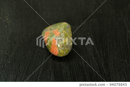 Unakite pebbles green epidote natural mineral stone from Republic of South Africa RSA. Mineralogy, geology, magic of stones, semi-precious stones and samples of minerals. Close-up macro photo. Unakite pebbles green epidote natural mineral stone from Republic of South Africa RSA. Mineralogy, geology, magic of stones, semi-precious stones and samples of minerals. Close-up macro photo. 94079843