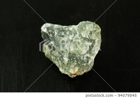 Prehnite green natural mineral stone from Republic of South Africa RSA on black background. Mineralogy, geology, magic of stones, semi-precious stones and samples of minerals. Close-up macro photo. 94079848