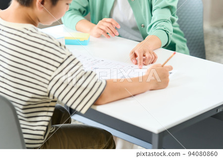 A woman who teaches studying Elementary school students studying 94080860