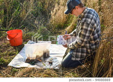 Farmer preparing soil samples for laboratory analysis outdoors Farmer preparing soil samples for laboratory analysis outdoors 94080869