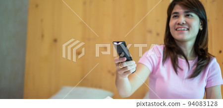 woman hand using remote controller for adjust Smart TV inside the modern room at home woman hand using remote controller for adjust Smart TV inside the modern room at home 94083128