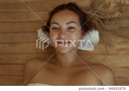 Beautiful young woman relaxing in Finnish sauna 94083876
