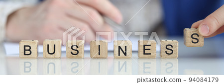 Person puts letter s in word business 94084179