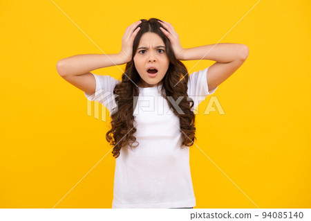 Portrait of angry teen girl looking at camera isolated on studio background. Unhappy upset teenager child. 94085140
