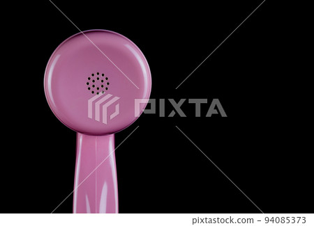 Pink Telephone Receiver Earpiece on a Black Background 94085373