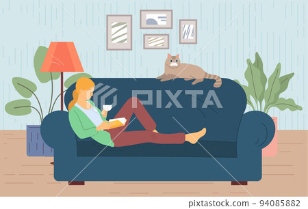 Woman reads book on couch at cosy home. Girl sitting on sofa with her cat, reading book and resting Woman reads book on couch at cosy home. Girl sitting on sofa with her cat, reading book and resting 94085882
