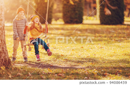 Couple of children playing in the autumnal park. Couple of children playing in the autumnal park. 94086439