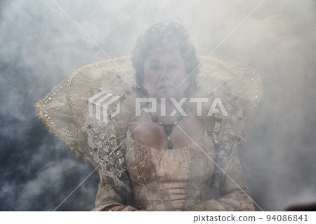 Portrait of the image of Queen Elizabeth I of the 16th century. Historical reconstruction. The image of the queen in smoke on a gray background. High quality photo 94086841