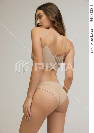Back view of young woman in underwear isolated on gray background. Natural beauty concept. Wellness, weight loss, treatment 94088061