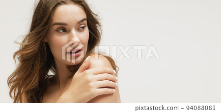 Closeup portrait of young cheerful beautiful girl with curly long hair smiling and looking at camera with happy and relaxed face expression 94088081