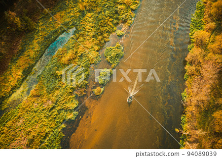 Aerial view of forest woods, marsh bog and river in sunny autumn landscape. Bird's eye view. Top view of beautiful european nature from high attitude in autumn season. Drone view Aerial view of forest woods, marsh bog and river in sunny autumn landscape. Bird's eye view. Top view of beautiful european nature from high attitude in autumn season. Drone view 94089039