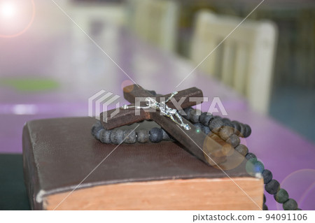 Brown wooden cross holding in hand soft and selective focus on the cross Brown wooden cross holding in hand soft and selective focus on the cross 94091106