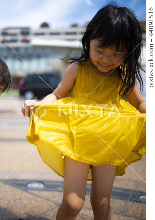 A girl bathing and playing in the fountain in the square in front of the station 94091516