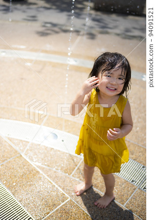 一個女孩在車站前廣場的噴泉里洗澡玩耍 94091521