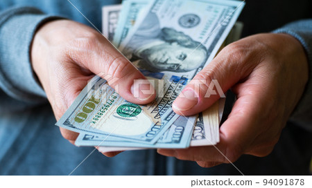 White female model shows dollar bills in her hand closeup front view 94091878