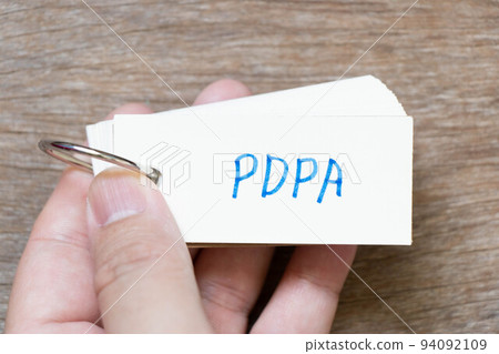 Hand hold flash card with handwriting in word PDPA (Abbreviation of personal data protection act) on wood background 94092109