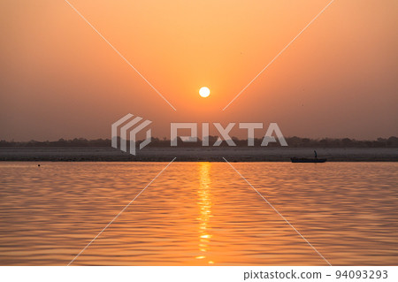India Varanasi early morning Ganges river and the sky dyed orange in the morning sun India Varanasi early morning Ganges river and the sky dyed orange in the morning sun 94093293