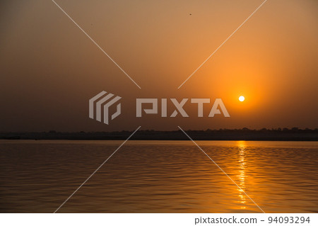 India Varanasi early morning Ganges river and the sky dyed orange in the morning sun India Varanasi early morning Ganges river and the sky dyed orange in the morning sun 94093294