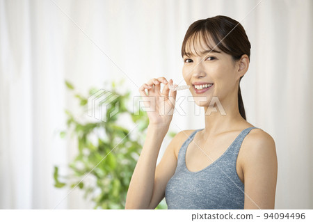 Woman holding a mouthpiece with one hand 94094496