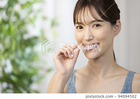 Woman holding a mouthpiece with one hand 94094502